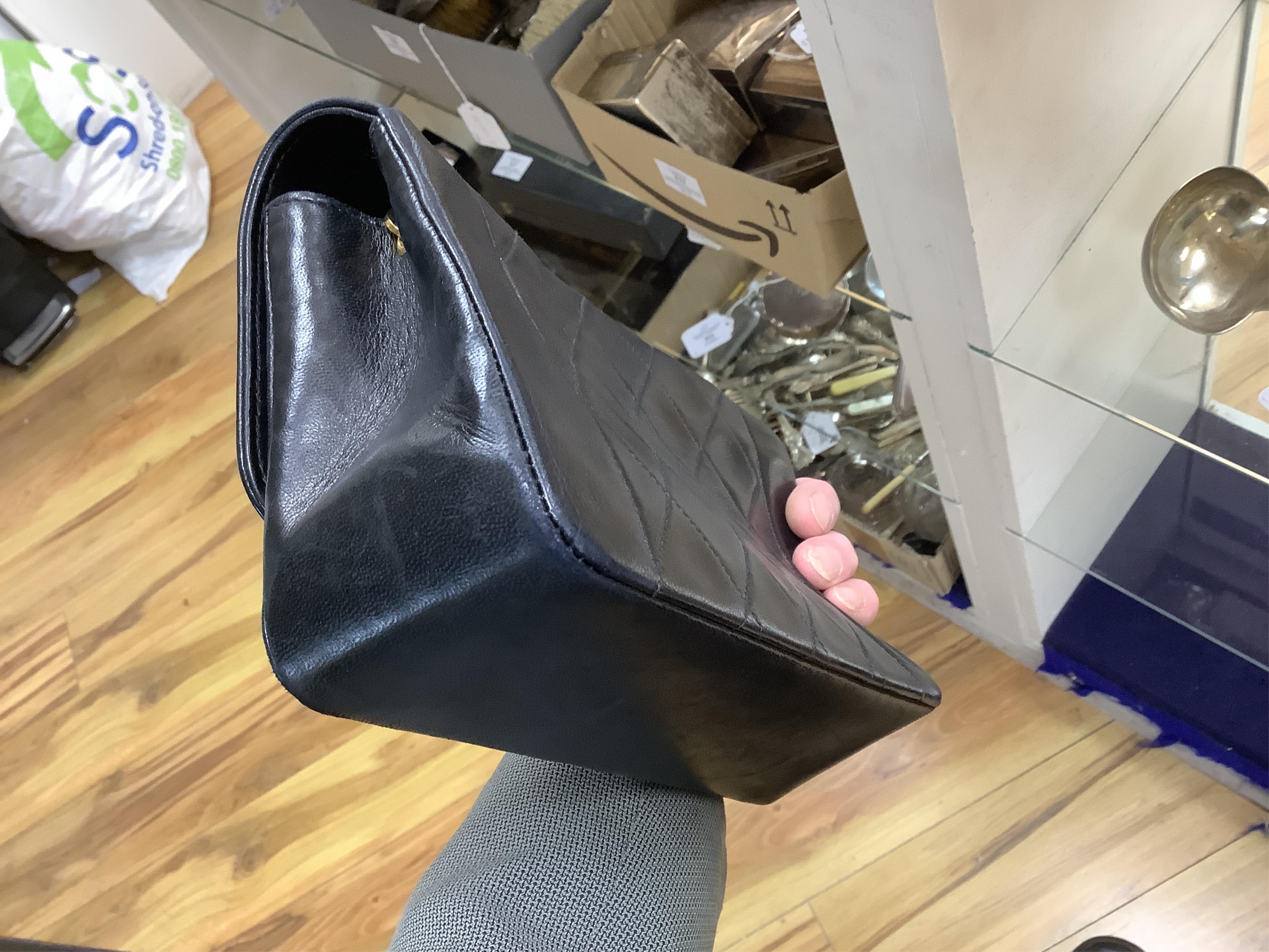 A late 1980’s Chanel black leather Diana shoulder bag with original dust cover and bag, Chanel authenticity card numbered 1944645, interior date code rubbed, 23cm wide, Provenance: Purchased by the vendor, 26 Old Bond St